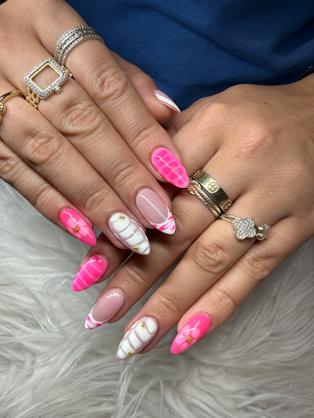 Hot pink and white almond nails with marble swirls, pink French tips and small gold accents by Chic Nail and Head Spa