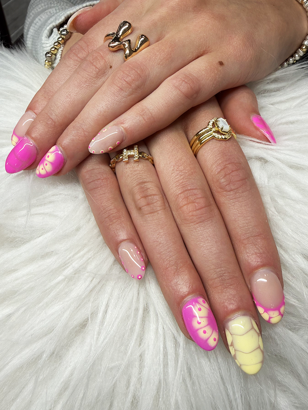 Bright pink and yellow almond nails with retro floral patterns and dotted swirl details by Chic Nail and Head Spa